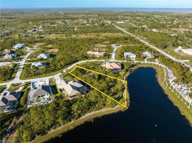Aerial view of residential area with a large body of water and property boundaries highlighted