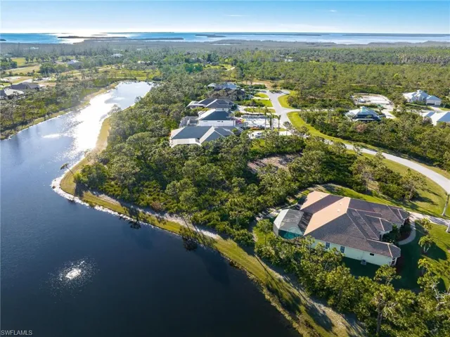 Aerial view of property's location with a large body of water and a forest