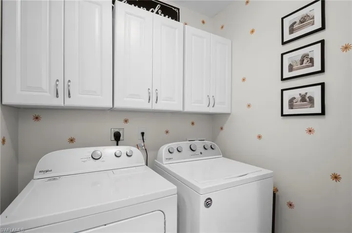 Washroom with washing machine and clothes dryer and cabinet space