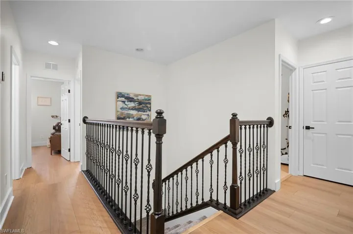 Corridor with an upstairs landing, recessed lighting, and light wood finished floors
