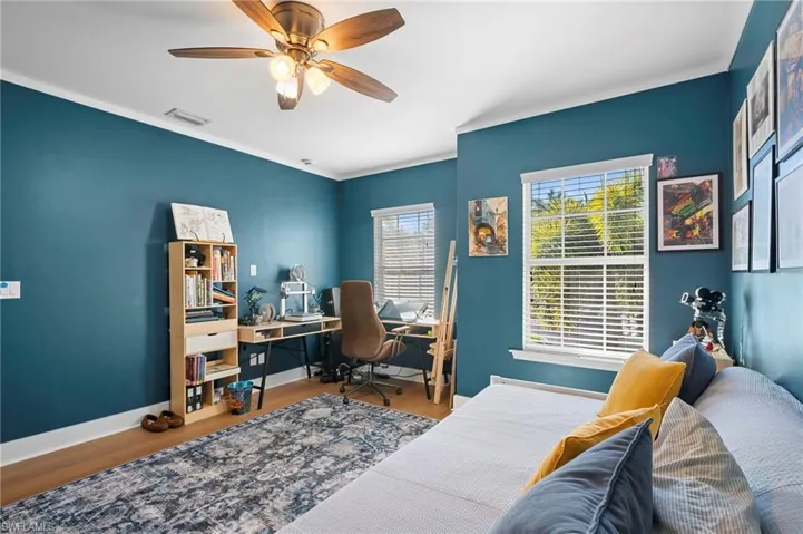 Office area featuring wood finished floors, a ceiling fan, and ornamental molding