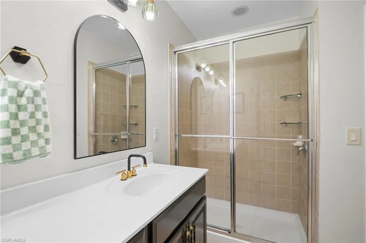 Full bath featuring vanity and a tile shower