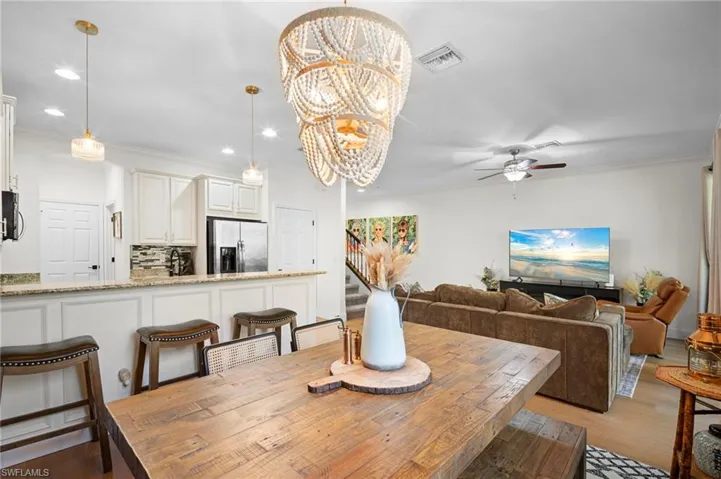 Dining area featuring a chandelier, ornamental molding, recessed lighting, stairs, and ceiling fan