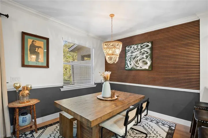 Dining area featuring a chandelier, wood finished floors, and ornamental molding