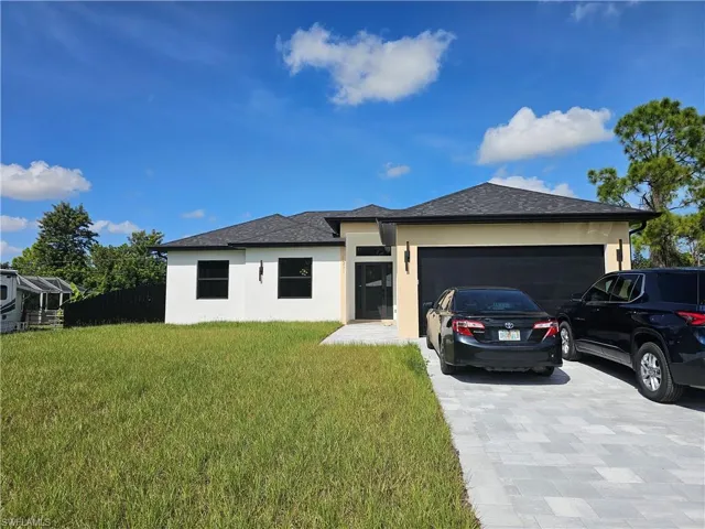 Contemporary single-story exterior with a two-car garage, large driveway, and a covered entryway