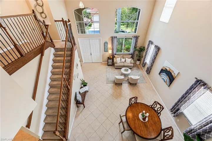 Living room with tile patterned flooring and a towering ceiling