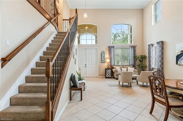 Entrance foyer with a towering ceiling, plenty of natural light, and light tile patterned floors