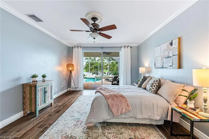 Bedroom with ceiling fan, ornamental molding, dark hardwood / wood-style floors, and access to exterior