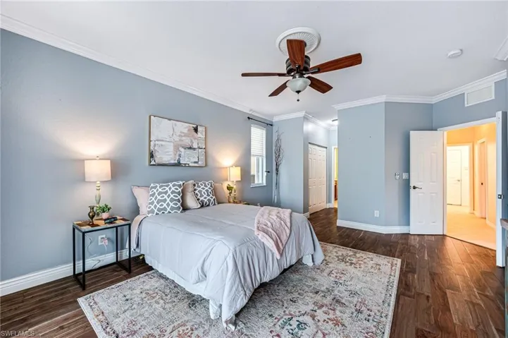 Bedroom featuring ceiling fan, crown molding, dark hardwood / wood-style flooring, and a closet
