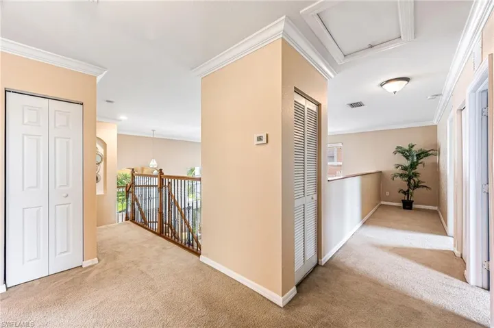 Hall featuring crown molding and light colored carpet