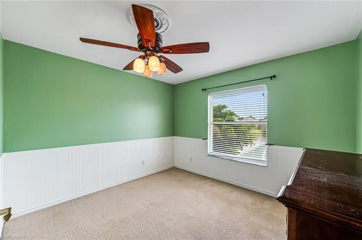 Empty room with ceiling fan and light colored carpet