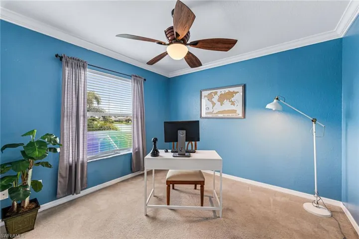 Carpeted office featuring crown molding and ceiling fan