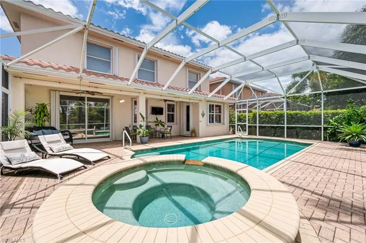 View of swimming pool featuring a lanai, a patio, and an in ground hot tub