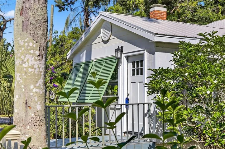 View of home's exterior featuring a chimney and a metal roof