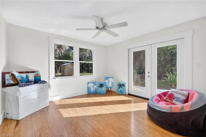 Bedroom featuring wood finished floors, french doors, and a ceiling fan