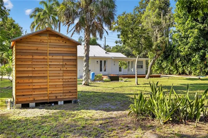 Back of property featuring french doors, a deck, a lawn