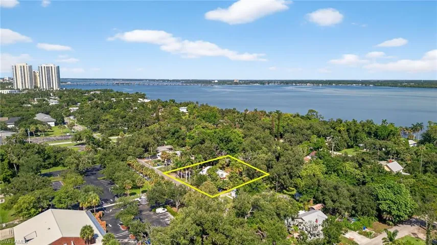 Aerial view of property and surrounding area featuring property parcel outlined and a River