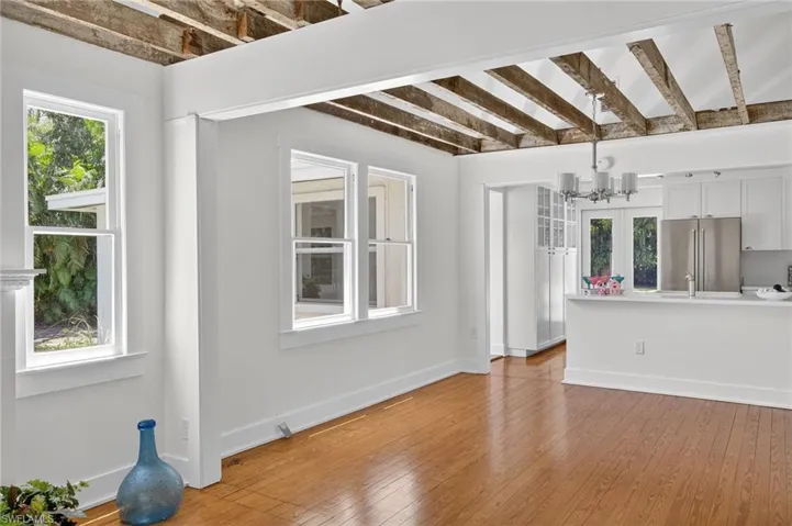 Unfurnished living room with wood floors, and beam ceiling