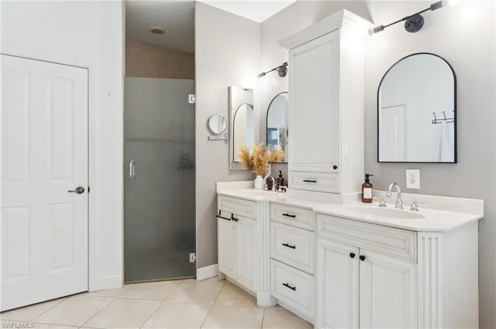 Bathroom featuring vanity, tile patterned flooring, and an enclosed shower