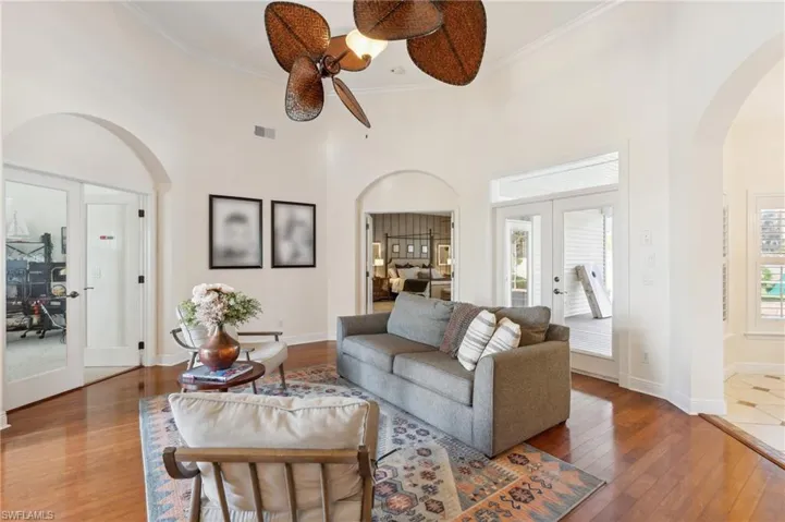 Living room with french doors, a high ceiling, a wealth of natural light, and hardwood / wood-style floors