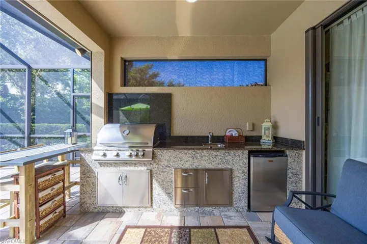 Outdoor gourmet kitchen with high-end grill, stone prep counters, and integrated dining area perfect for entertaining.
