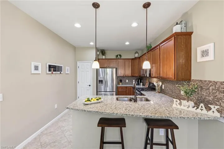 Modern kitchen featuring a spacious island, premium stainless steel appliances, and located in a desirable natural gas community.