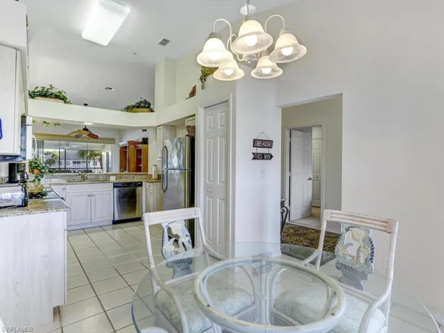 Dining room with light tile patterned floors and a towering ceiling