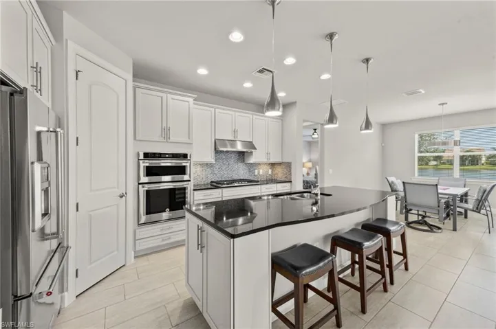 What a beautiful kitchen with island to include bar stools. GAS COOKING!