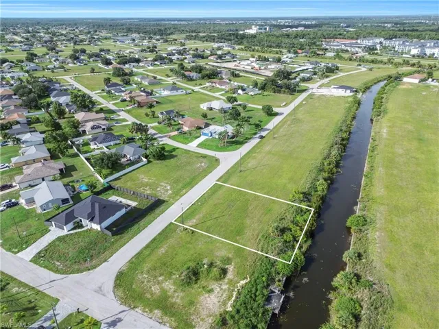 Expansive canal-front lot featuring lush green space