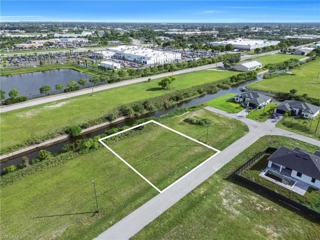 Cleared lot with direct road frontage, surrounded by expansive green spaces