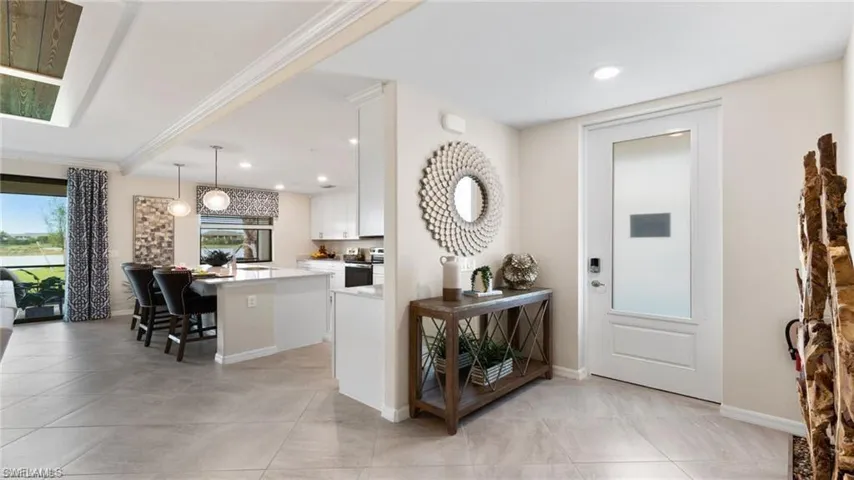 Entryway featuring light tile patterned floors, recessed lighting, baseboards, and crown molding