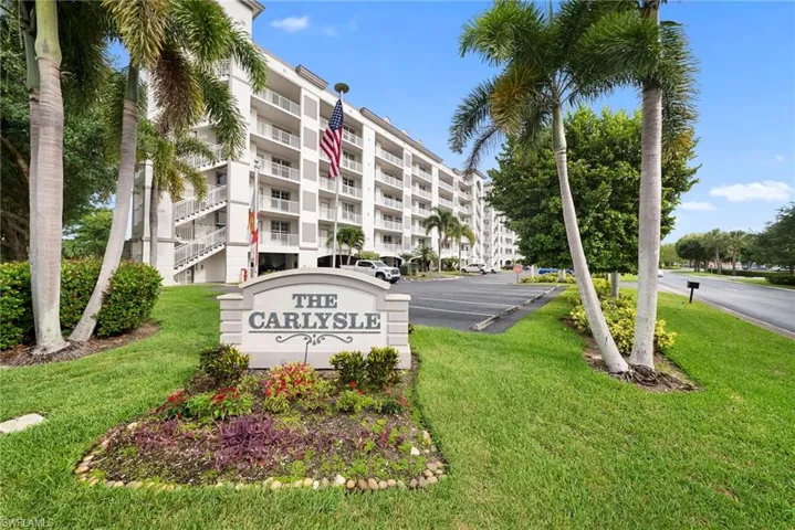 The Carlysle building with multiple balconies, exterior staircases, and surrounding tropical landscaping