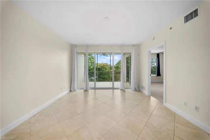 Bright interior space featuring light-toned tile flooring, white baseboards, and neutral wall tones