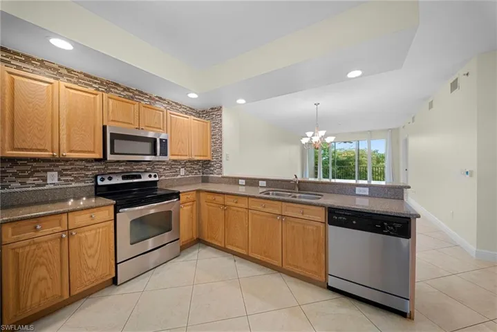 U-shaped kitchen with wood cabinetry and stone countertops