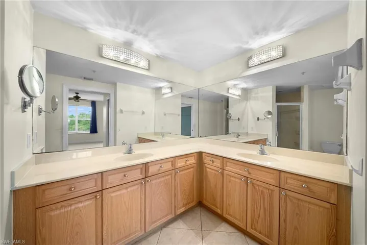Dual vanity with light-toned countertops and natural wood-finish cabinetry