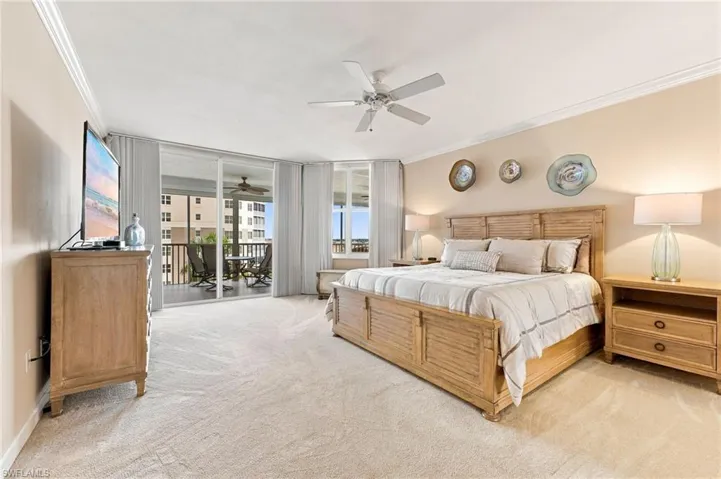 The oversized primary suite offers plush carpeting and direct access to the lanai, creating a serene private retreat where you can relax and enjoy the beautiful waterfront surroundings.