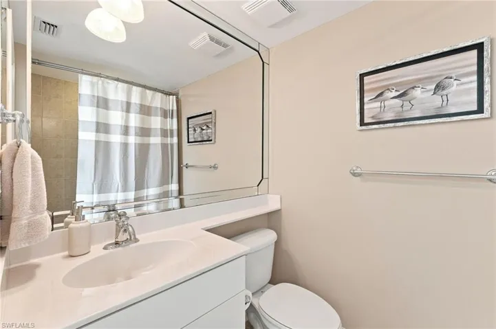 The ensuite bath features a sleek single vanity and a convenient shower-tub combination, offering both style and functionality.