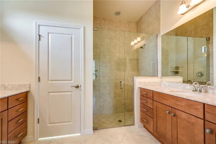 Bathroom featuring vanity, a stall shower, and light tile patterned floors