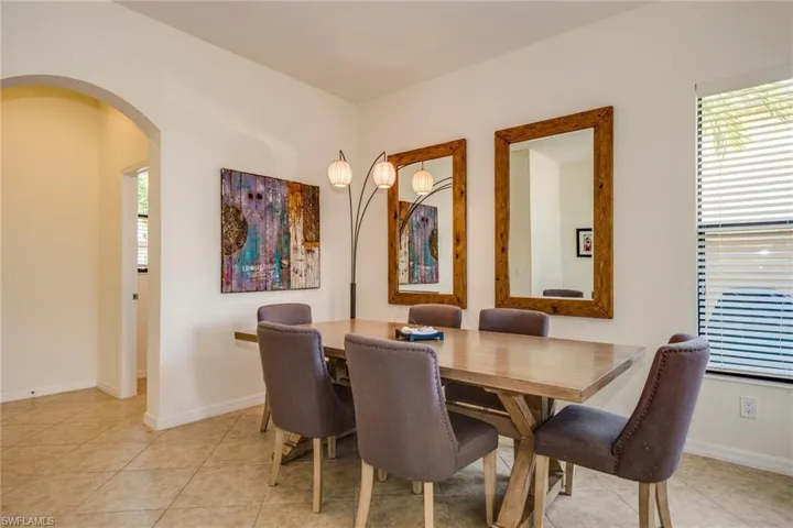 Dining space with arched walkways and light tile patterned flooring