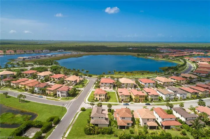 Aerial view of property and surrounding area featuring a nearby body of water and nearby suburban area
