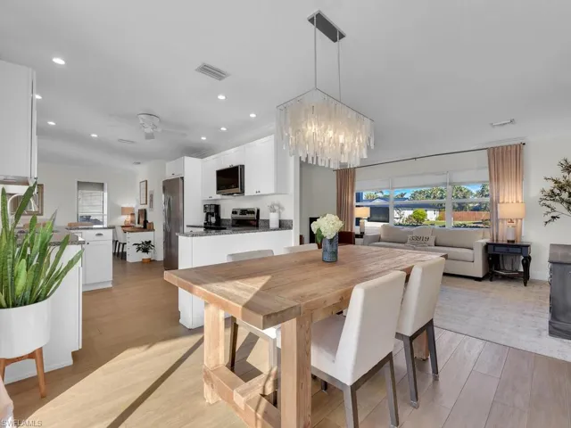 Dining space featuring ceiling fan with notable chandelier and light hardwood / wood-style flooring