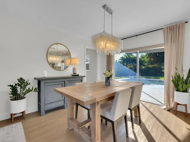Dining room with light wood-type flooring and a chandelier