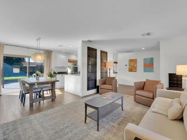 Living room with light hardwood / wood-style floors and an inviting chandelier