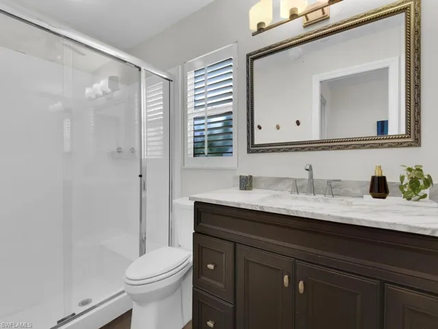 Bathroom featuring vanity, toilet, and walk in shower