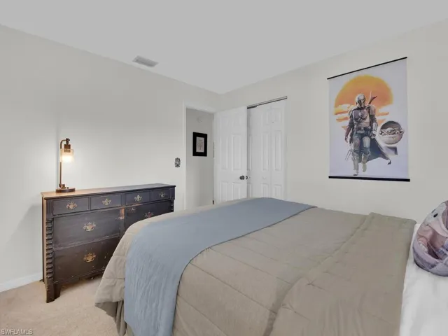 Carpeted bedroom with a closet