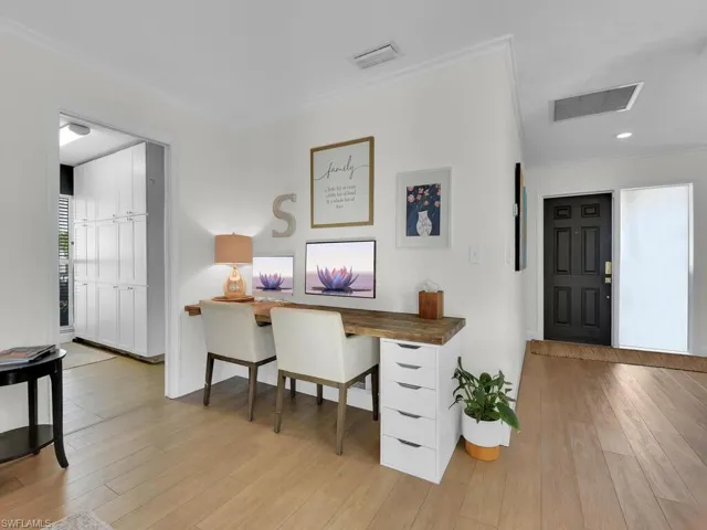 Home office featuring light hardwood / wood-style floors and crown molding