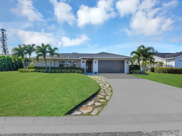 Single story home with a front yard and a garage