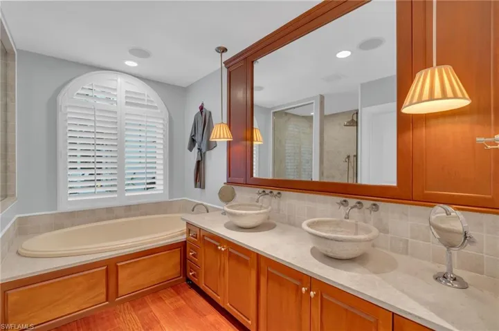 Bathroom featuring vanity, shower with separate bathtub, wood-type flooring, and tasteful backsplash