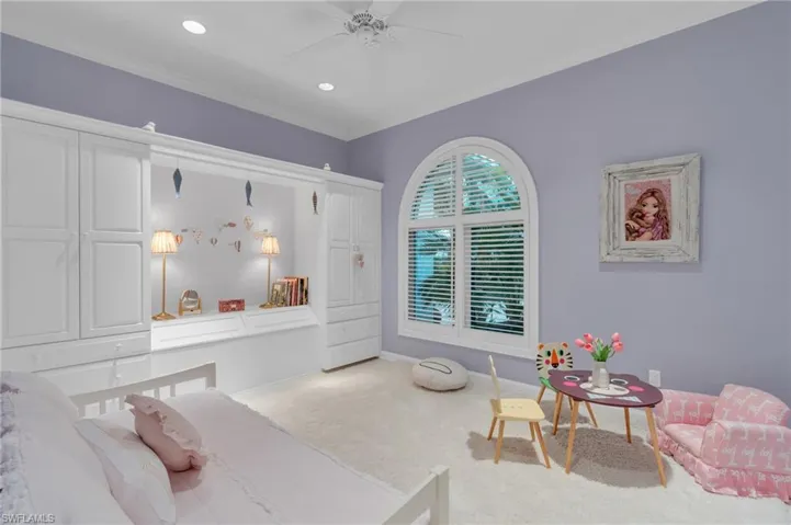 Bedroom with ceiling fan, carpet, and ornamental molding