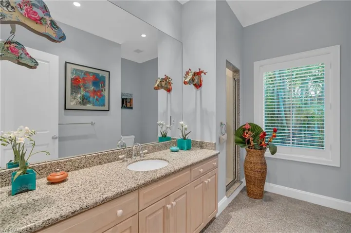 Bathroom featuring a shower with shower door, vanity, and crown molding